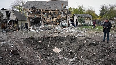 A man looks at a crater after a Russian missile strike in Kyiv, Ukraine, Thursday, Oct. 22, 2026.
