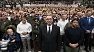 Serbia's populist leader Aleksandar Vucic, center, listens to the Serbian national anthem with supporters during a pre-election rally.