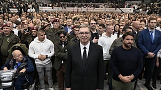 Serbia's populist leader Aleksandar Vucic, center, listens to the Serbian national anthem with supporters during a pre-election rally.