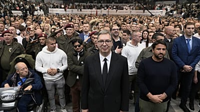 Il leader populista serbo Aleksandar Vucic, al centro, ascolta l'inno nazionale con i sostenitori durante un comizio pre-elettorale.