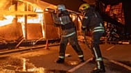 Firefighters try to put out a fire at a shopping store following Russia's air attack in Kharkiv, Ukraine, Sunday, Oct. 25, 2026.