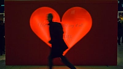 Un hombre pasa corriendo ante un quiosco que vende regalos de San Valentín mientras corre para tomar un tren en la estación de Waterloo, en Londres, el 9 de febrero de 2010.