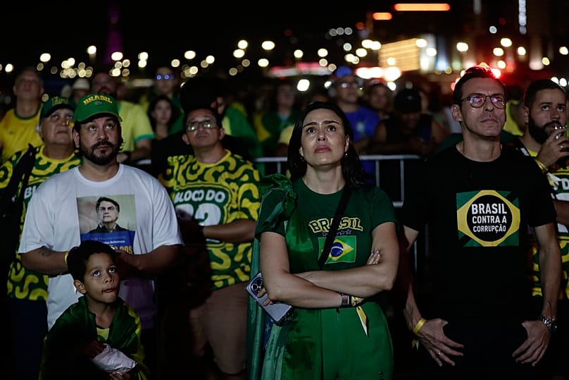 Supporters of opposition presidential candidate Sen. Flavio Bolsonaro react to presidential runoff results in Brasilia, Sunday, Oct. 25, 2026. 