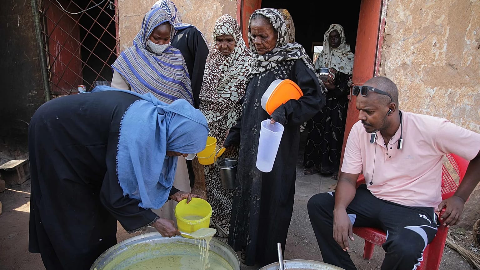 امرأة توزّع طعامًا على المحتاجين في مطبخ مجتمعي بالخرطوم، السودان، 23 أيلول/سبتمبر 2026. 