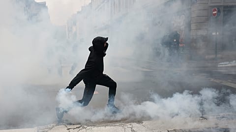 Διαδηλωτής εκτοξεύει χειροβομβίδα δακρυγόνων εναντίον της αστυνομίας μετά από πορεία κατά της αύξησης του κόστους ζωής στη Ρεν (Γαλλία), 24 Οκτωβρίου 2026.
