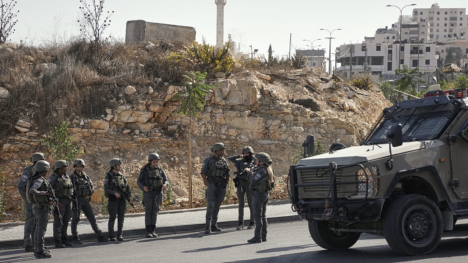 جنود إسرائيليون يتجمعون في موقع هجوم بإطلاق نار نفذه مسلحون فلسطينيون عند تقاطع طرق قرب مدينة الخليل في الضفة الغربية المحتلة، يوم الجمعة 23 أكتوبر 2026. (صورة من أسوشيتد برس/