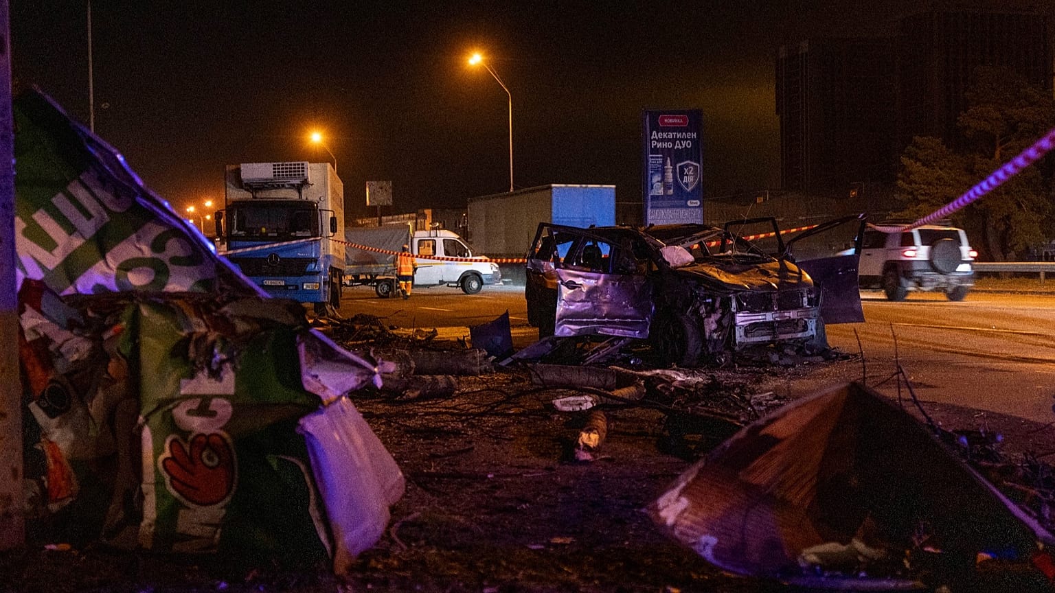 Emergency workers clear debris and damaged road infrastructure near a destroyed car following a Russian overnight strike in Kyiv, Ukraine, Tuesday, Oct. 27, 2026. 