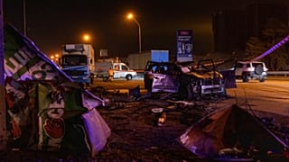 Emergency workers clear debris and damaged road infrastructure near a destroyed car following a Russian overnight strike in Kyiv, Ukraine, Tuesday, Oct. 27, 2026. 
