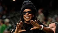 FILE - Jay-Z gestures from the sidelines prior to the NFL Super Bowl 59 football game, 9 Feb 2025, in New Orleans.