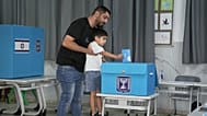 Ισραηλινός ψηφοφόρος ρίχνει την ψήφο του στην κάλπη με την βοήθεια του μικρού γιου του