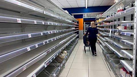 A woman walks past empty supermarkets shelves after a trucker strike brought food transport to a standstill in southern Italy, October 2026