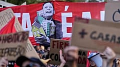 Αφίσα με την εικόνα του Λουίς Μοντενέγκρο να αγκαλιάζει ένα σύνολο σπιτιών, κατά τη διάρκεια διαδήλωσης για προσιτή στέγη στη Λισαβόνα, το Σάββατο 24 Οκτωβρίου 2026