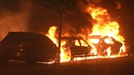 Varios coches arden durante los enfrentamientos entre manifestantes y la policía en Bilbao, en el norte de España, el lunes 26 de octubre de 2026.
