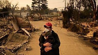 FILE: Ari Rivera, rear, and Anderson Hao hold each other in front of their destroyed home Jan. 9, 2025, in Altadena, Calif.