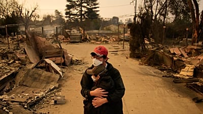 FOTO DE ARQUIVO: Ari Rivera, atrás, e Anderson Hao abraçam-se em frente da sua casa destruída, a 9 de janeiro de 2025, em Altadena, Califórnia