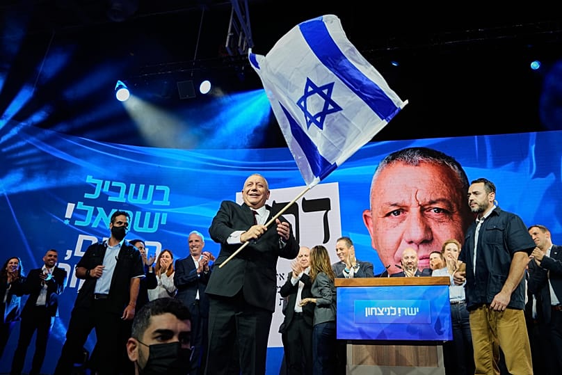 Gadi Eisenkot macha flagą Izraela na scenie po ogłoszeniu pierwszych wyników sondaży exit poll dotyczących wyborów parlamentarnych, w Izraelu, 28 października 2026 r. 