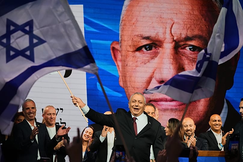 Gadi Eisenkot, líder do partido Yashar agita uma bandeira israelita no palco após a divulgação dos primeiros resultados das sondagens à boca das urnas. 28 outubro 2026