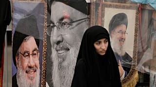 امرأة تقف بجانب صور لزعيم حزب الله الراحل حسن نصر الله بالقرب من ضريحه في بيروت، لبنان، يوم السبت 26 سبتمبر 2026