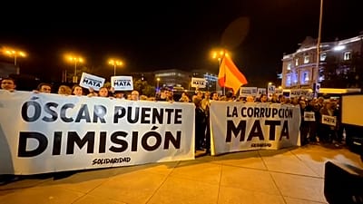 Personas guardan un minuto de silencio sosteniendo pancartas con los lemas «Óscar Puente, dimisión» y «La corrupción mata».