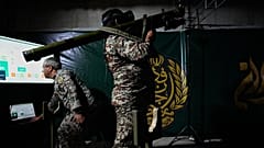أحد أفراد الجيش الإيراني يستعرض كيفية استخدام سلاح يُحمل على الكتف، مستعيناً بجهاز محاكاة، وذلك خلال مراسم افتتاح أحد مراكز التدريب العسكري للمتطوعين، والتي يجري إنشاؤها في سا