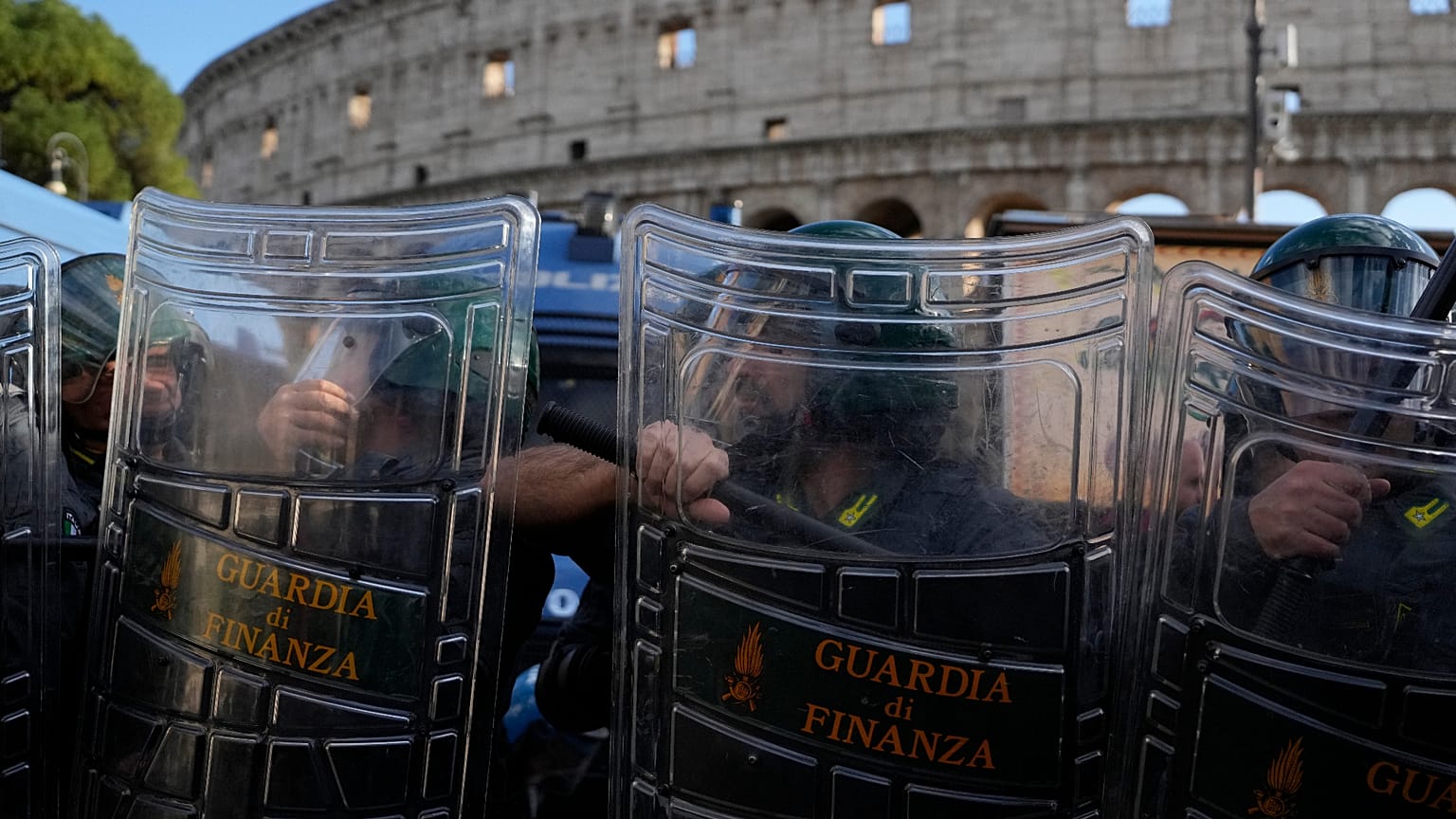 Polícia de choque italiana observa ativistas pacifistas a protestar contra o rearme e o envolvimento da Itália em guerras em frente ao Coliseu, em Roma, 24 out. 2026