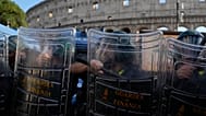 Italian anti-riot police watch antiwar activists demonstrating against rearmament and Italy's involvement in wars in front of the Colosseum in Rome, Saturday, Oct. 24, 2026