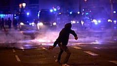 ARCHIVO: Un manifestante lanza piedras a la Policía durante enfrentamientos tras una protesta por la crisis de la vivienda en España.