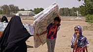 صبي يمني نازح يجلس فوق أكياس من المساعدات الغذائية في منطقة صلاح الدين بضواحي عدن