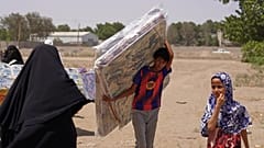 صبي يمني نازح يجلس فوق أكياس من المساعدات الغذائية في منطقة صلاح الدين بضواحي عدن