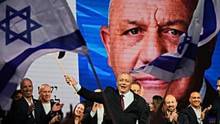Gadi Eisenkot, líder do partido Yashar (“Straight”), agita uma bandeira israelita em palco após os primeiros resultados de sondagens à boca de urna. 28 de outubro de 2026