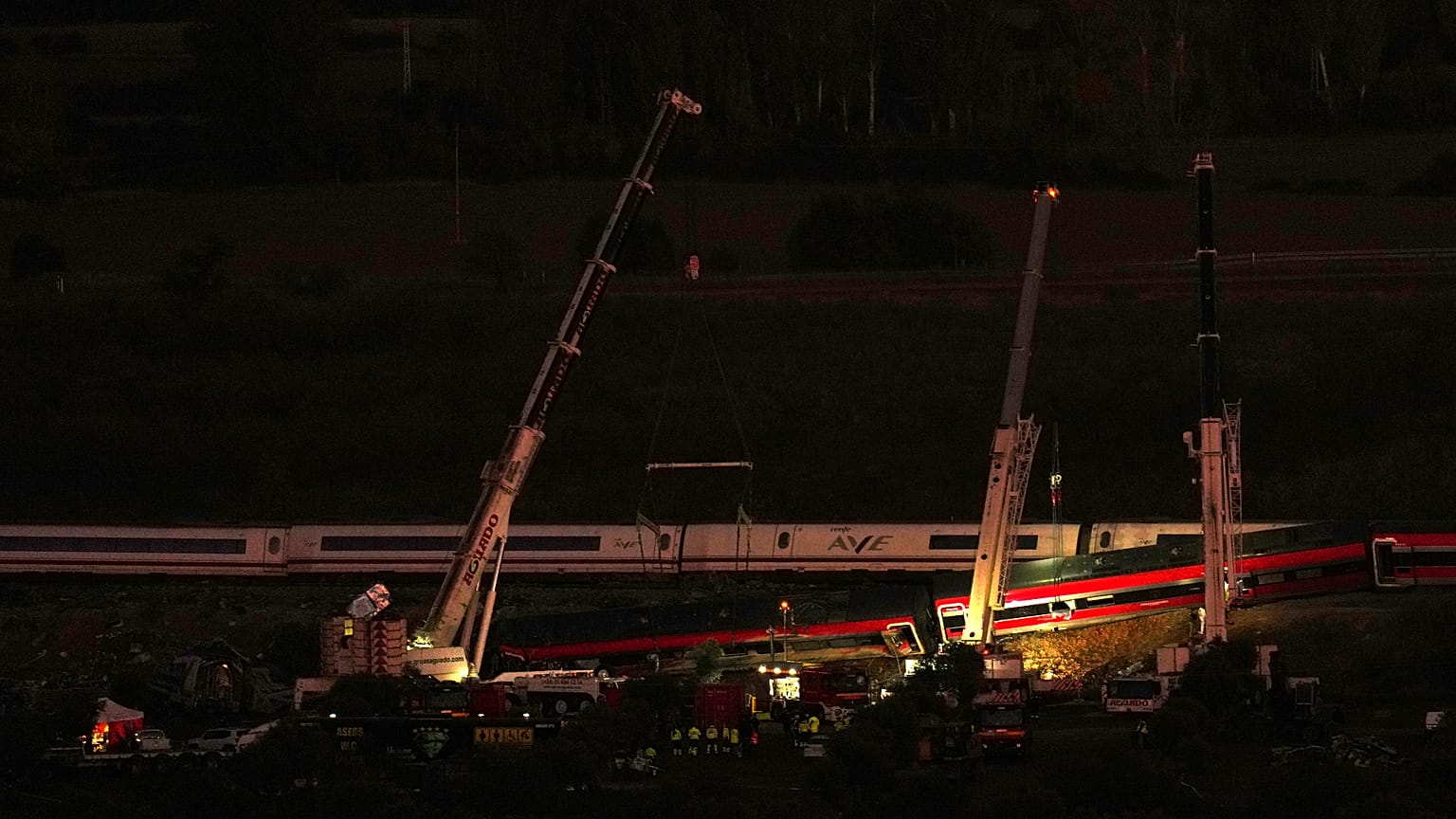 Unas grúas levantan los vagones destrozados mientras los equipos de rescate buscan a las víctimas tras una colisión entre dos trenes en Urda, España, el jueves 29 de octubre d
