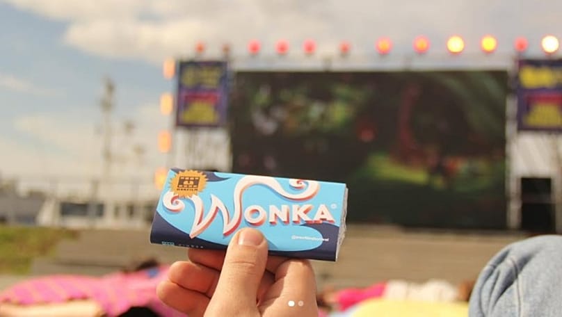 Un espectador sostiene una barrita de chocolate Wonka mientras se proyecta 'Charlie y la fábrica de chocolate'