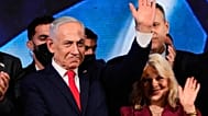 رئيس الوزراء الإسرائيلي بنيامين نتنياهو، برفقة زوجته سارة، يلوح لأنصاره في مقر حزب الليكود بالقدس