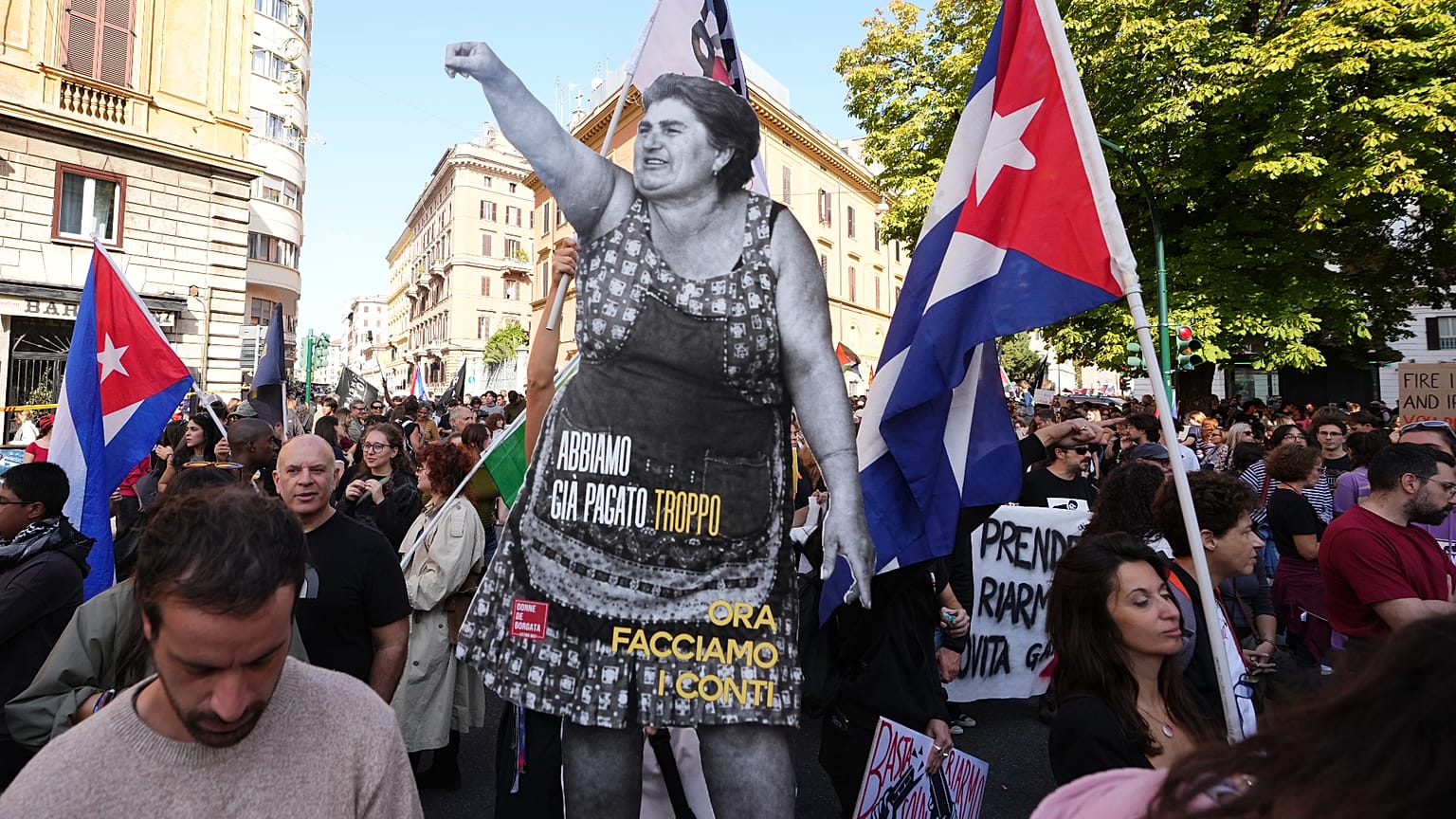 A tüntetők egy ökölét felemelő nőt ábrázoló, életnagyságú kartonfigurát visznek, rajta a felirat: „Már túl sokat fizettünk, most egyenlítsük ki a számlát.”