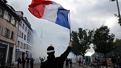 Demonstrant trzyma francuską flagę podczas protestu przeciw rosnącym kosztom życia w Strasburgu we Francji, 24 października 2026 r.