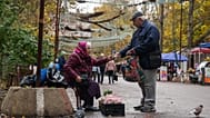  A man buys vegetables at a market beneath anti-drone nets during a local ceasefire linked to a humanitarian aid mission in Oleshky, Ukraine, on 29 October 2026.