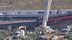 Una grúa trabaja en el lugar donde se encuentran los vagones de tren siniestrados tras una colisión entre dos trenes en Urda, España, el viernes 30 de octubre de 2026.