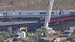 Una grúa trabaja en el lugar donde se encuentran los vagones de tren siniestrados tras una colisión entre dos trenes en Urda, España, el viernes 30 de octubre de 2026.