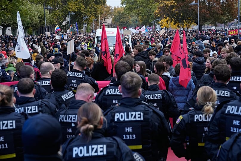 Police officers stand in front of demonstrators during a protest under the slogan "Gen Z Takes Care of It" in Berlin, Germany, Saturday, Oct. 31, 2026.